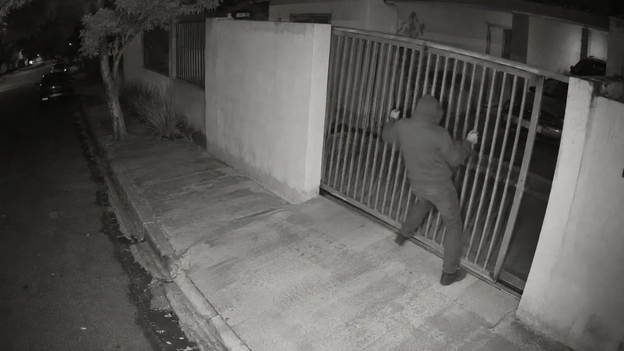 Câmera 4: pessoa encapuzada forçando o portão da fachada